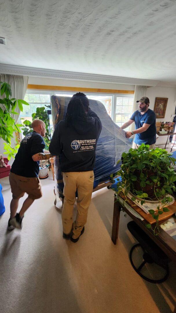 A group of people moving furniture in a room.