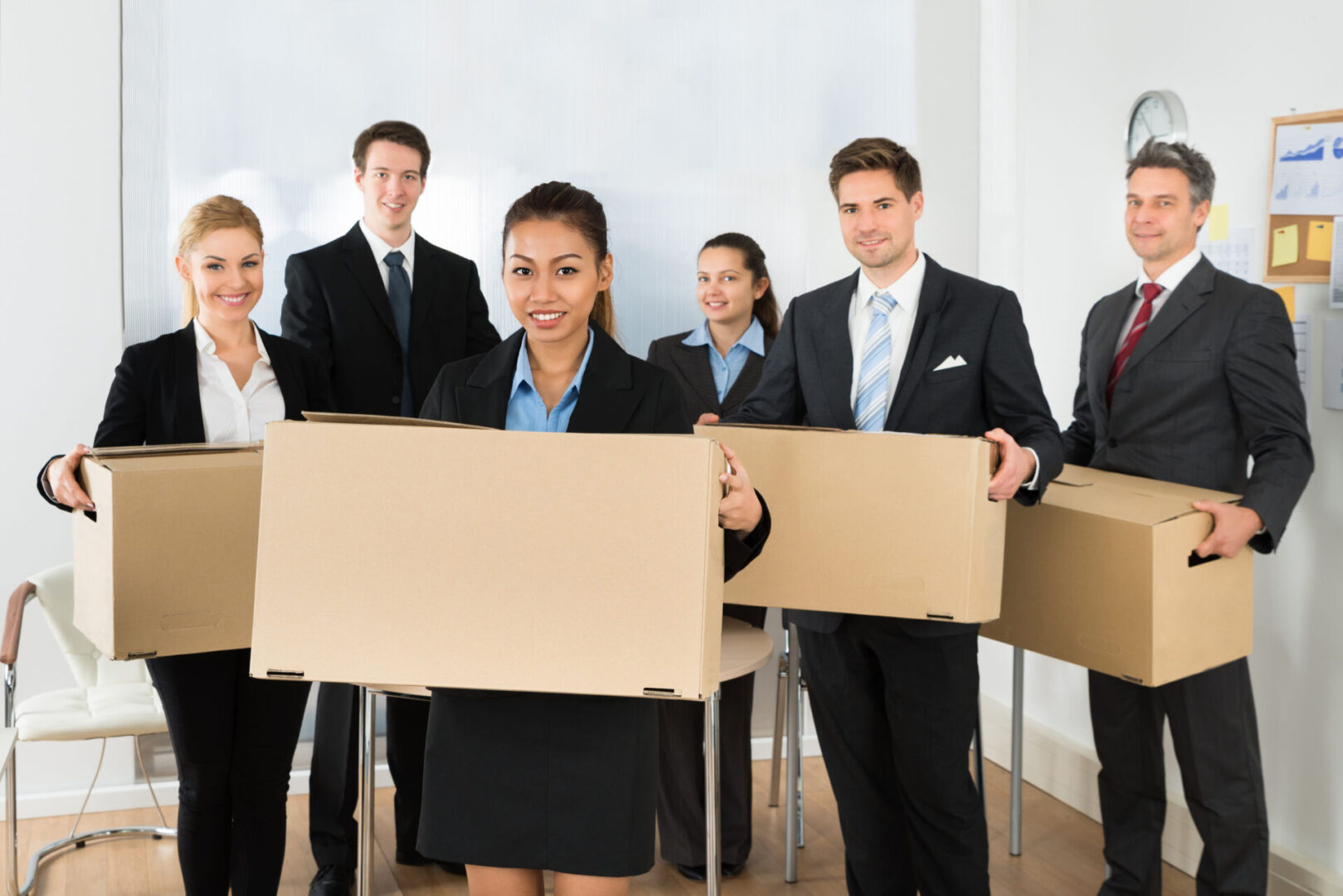 A group of people holding boxes in front of them.