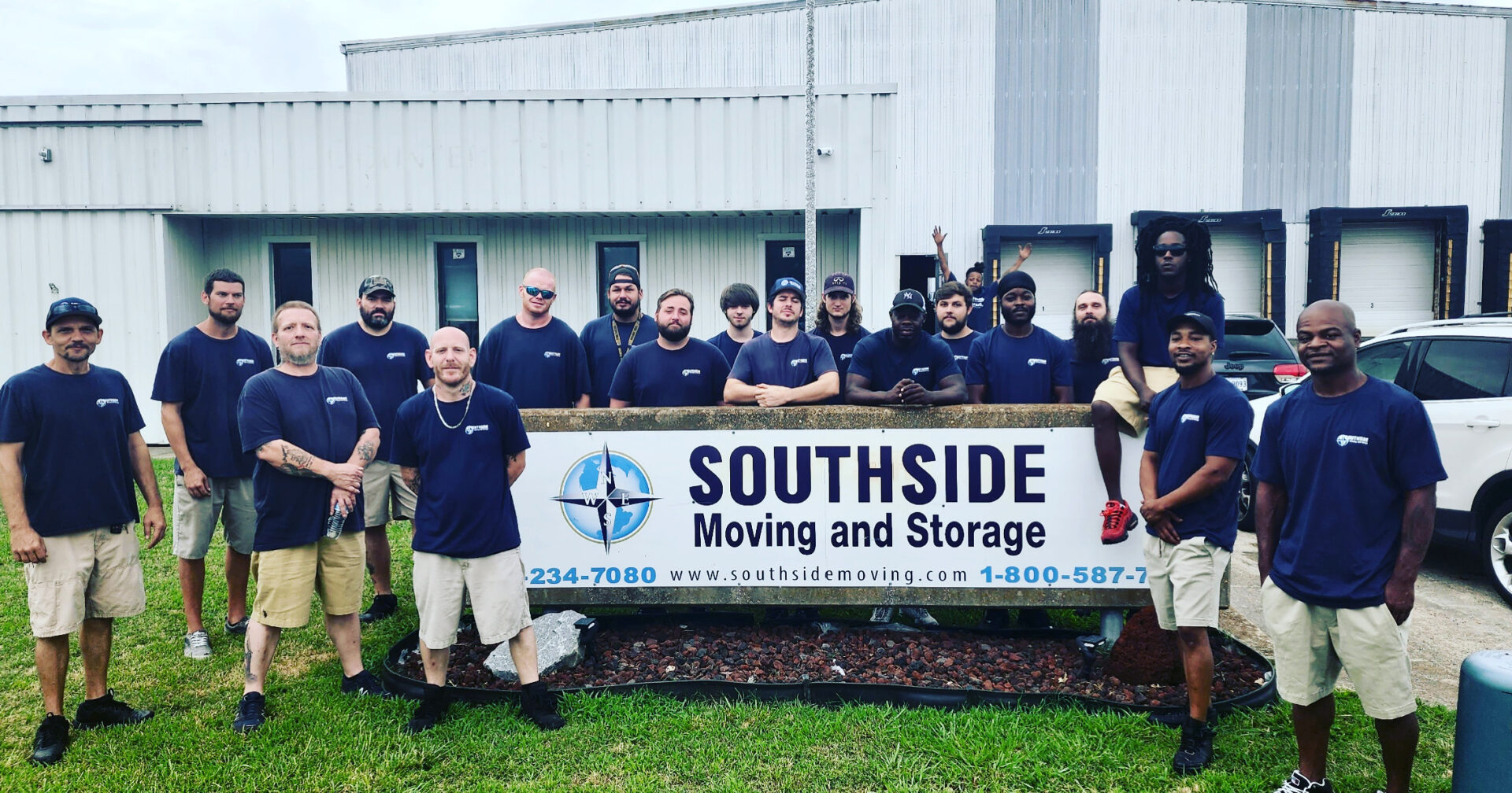 A group of people standing in front of a sign.