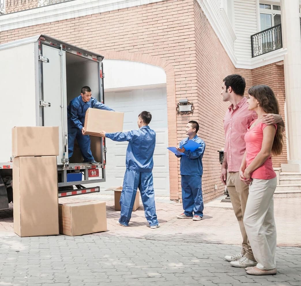 A group of people standing around moving boxes.