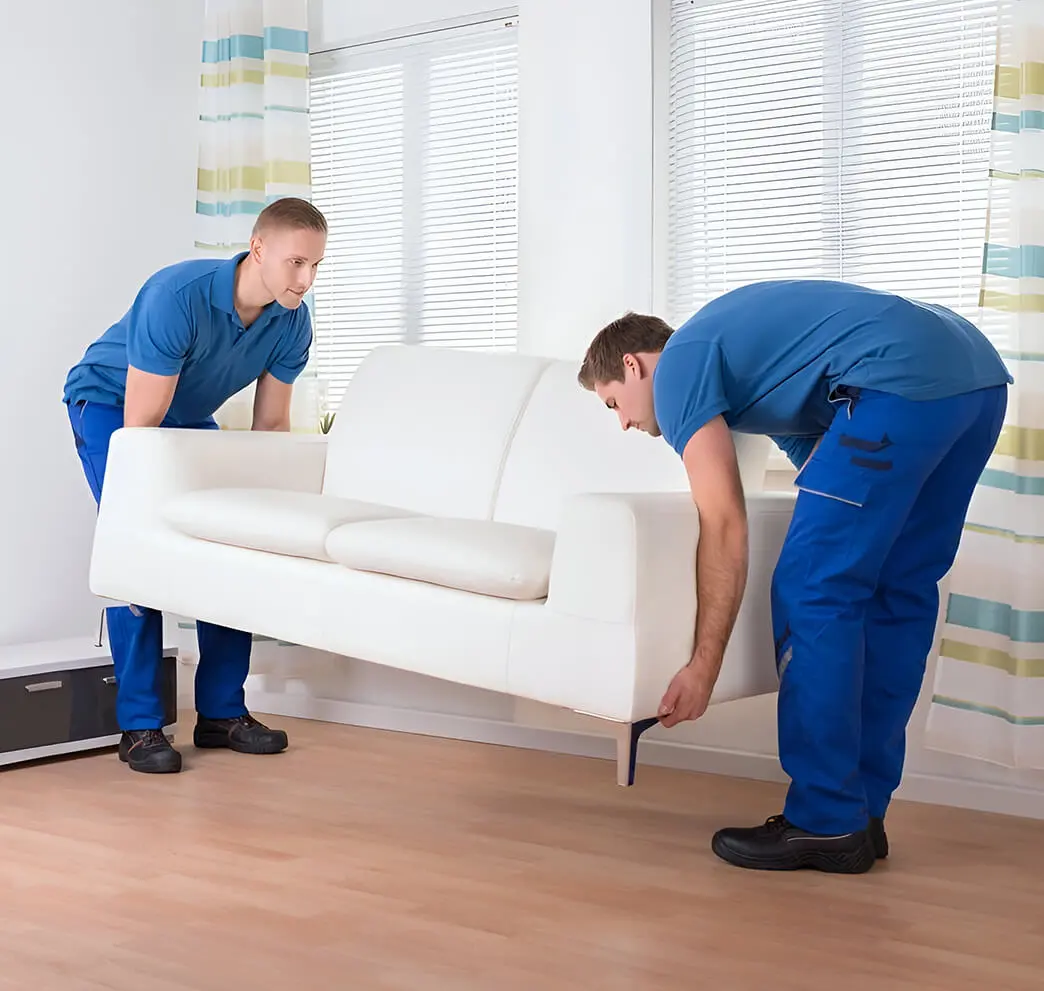 Two men moving a couch in a room.