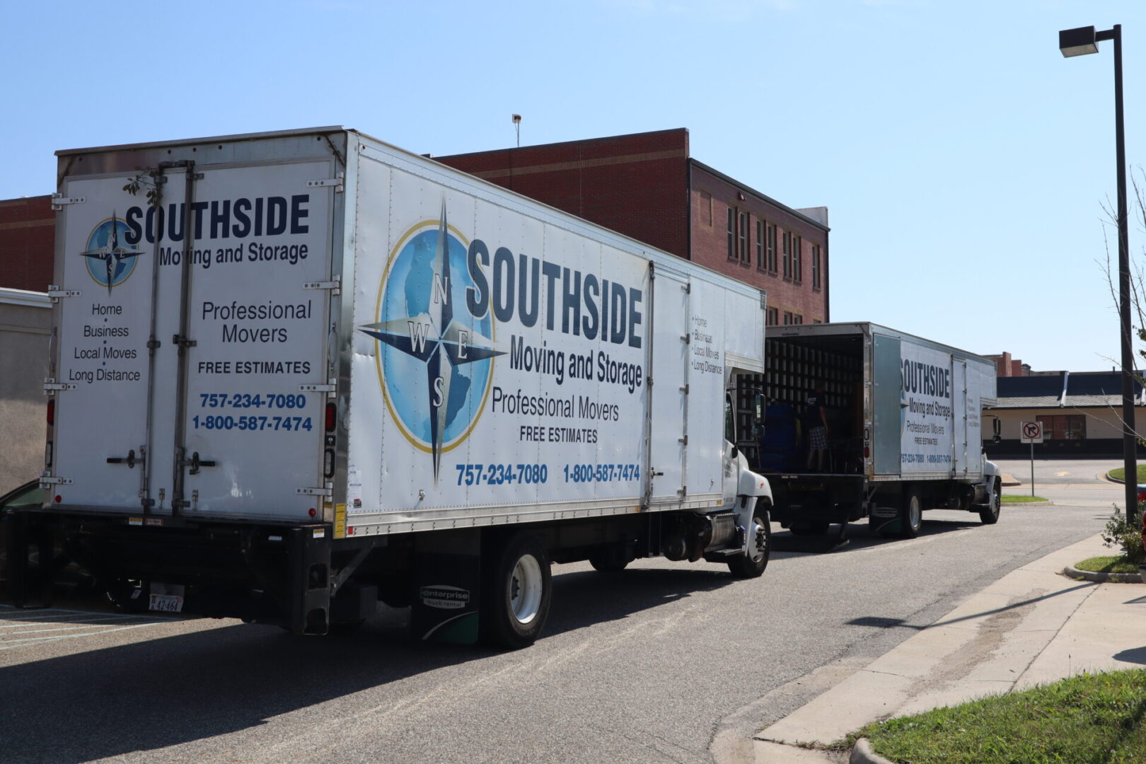 A truck with two trailers parked on the side of the road.