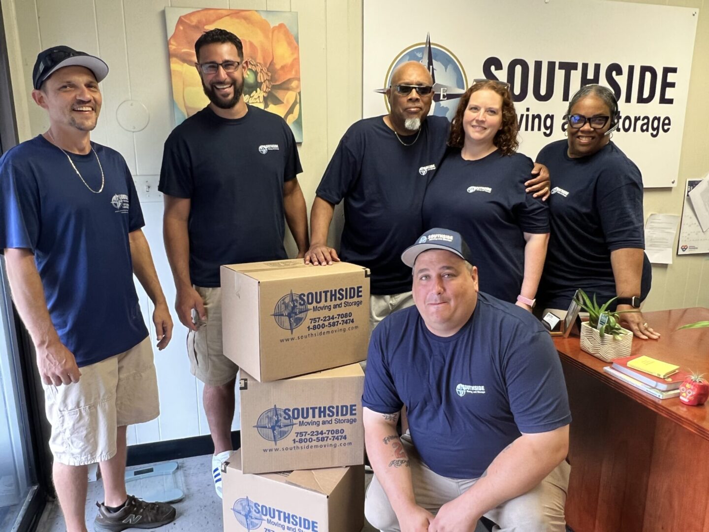 A group of people standing around boxes in a room.