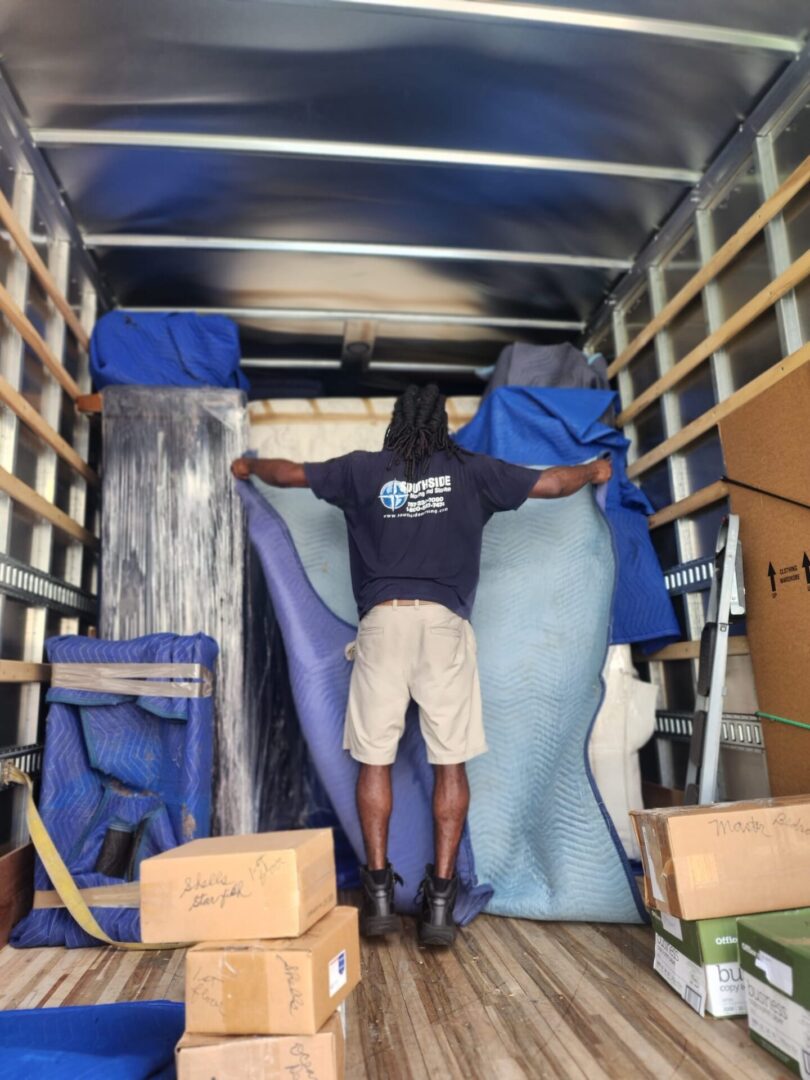 A man standing in the back of a moving truck.