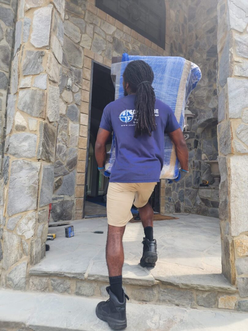 A man carrying a blue couch down the stairs.