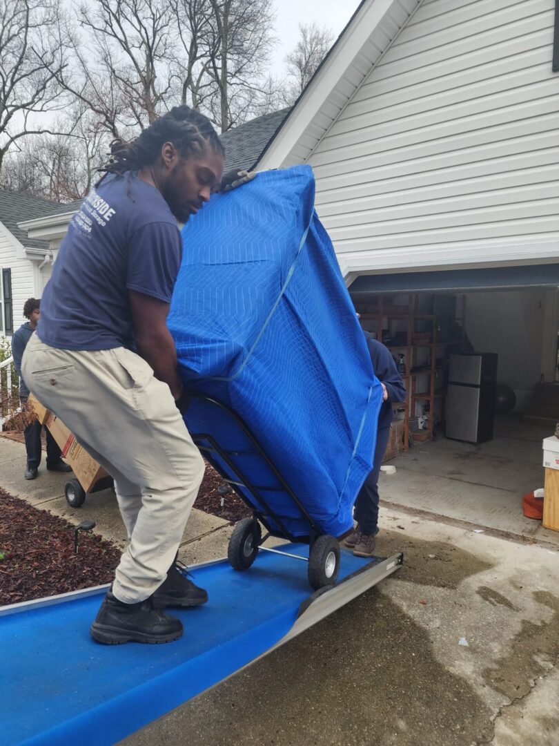 A man moving furniture on a dolly.