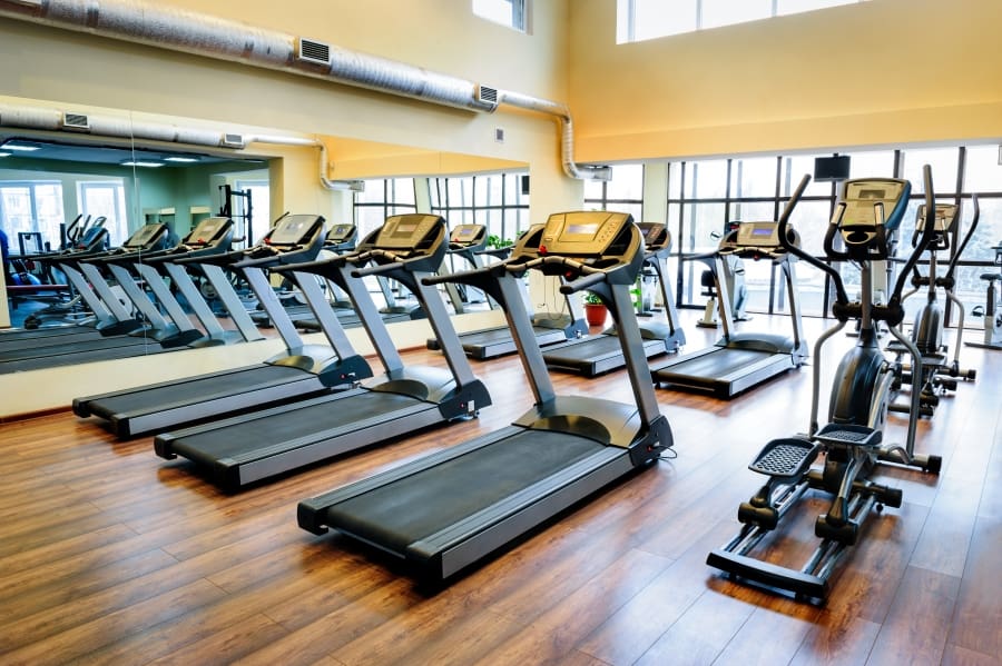 A gym with many treadmills and other equipment.