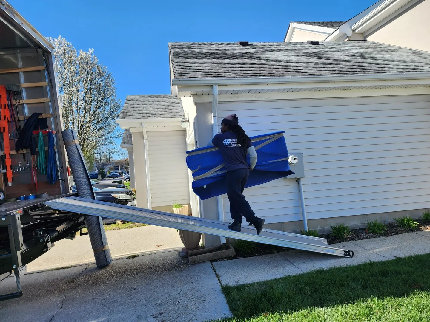 A man carrying a large blue object on top of a ramp.