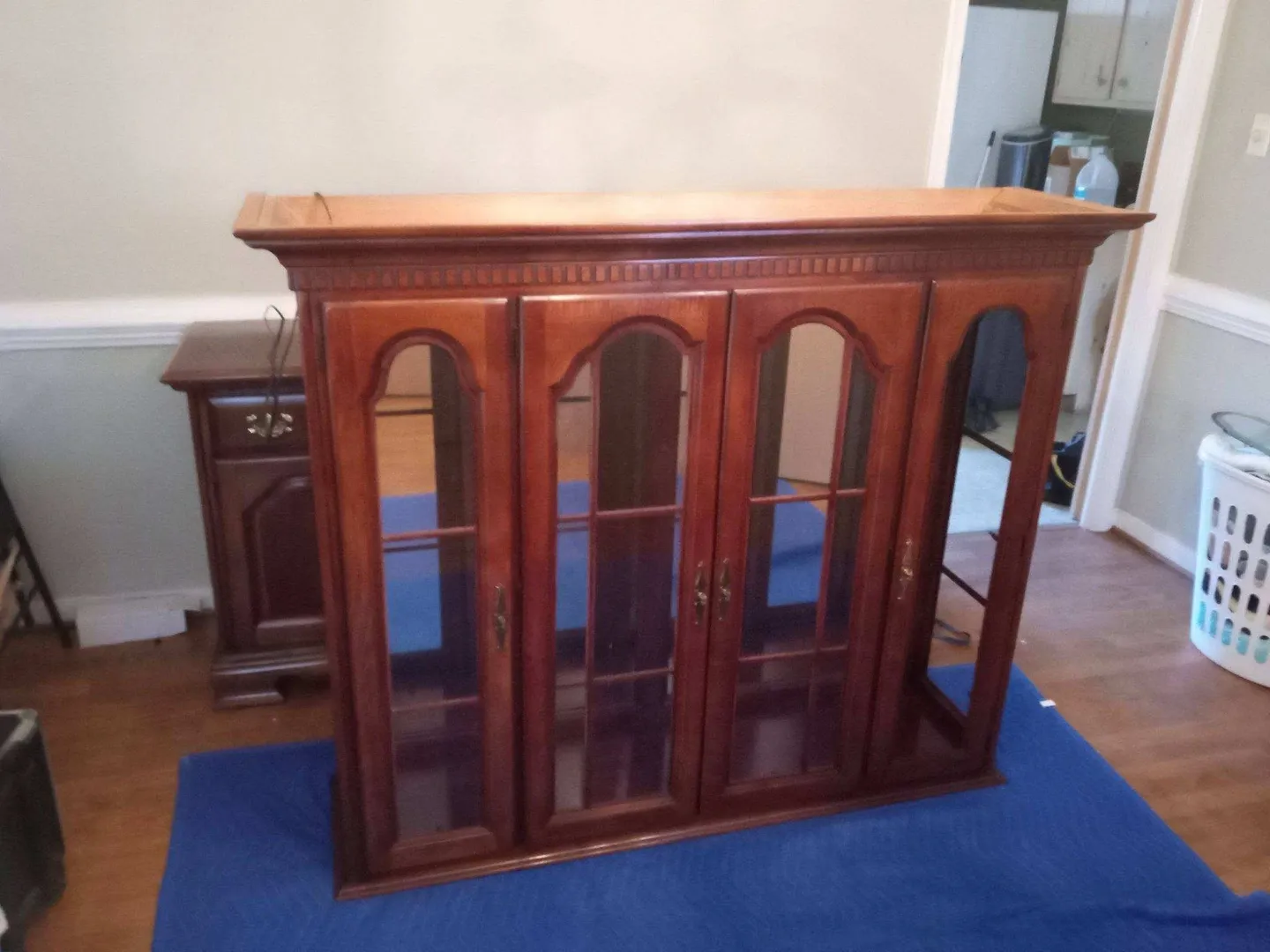 A large wooden cabinet with glass doors and shelves.