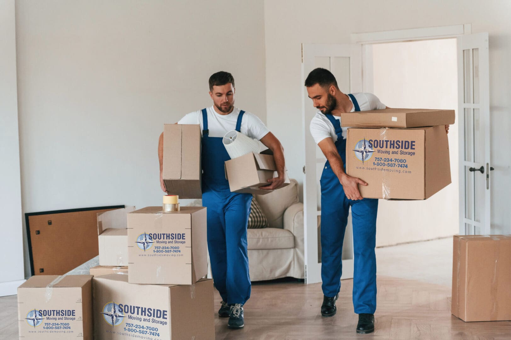 Front view, holding stuff. Two moving service employees in a room Front view, holding stuff. Two moving service employees in a room.