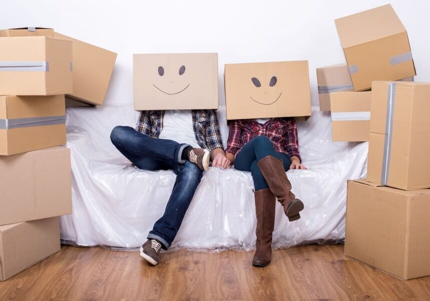 Two people sitting on a couch with boxes on their heads