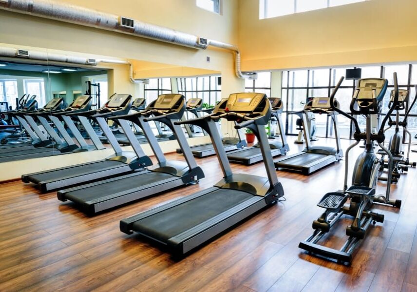 A gym with many treadmills and other equipment.